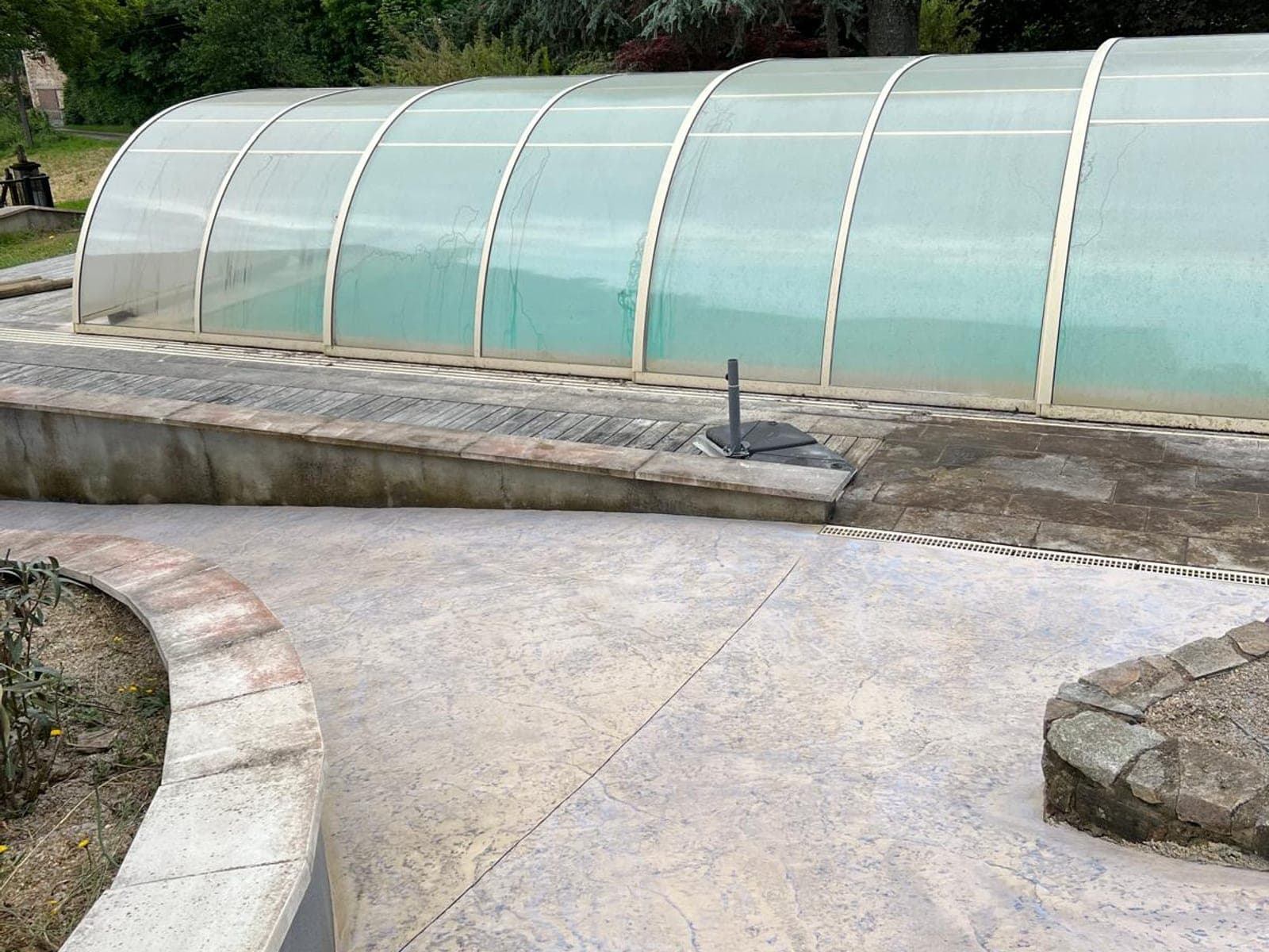 Zonă exterioară lângă piscină cu beton amprentat deschis la culoare